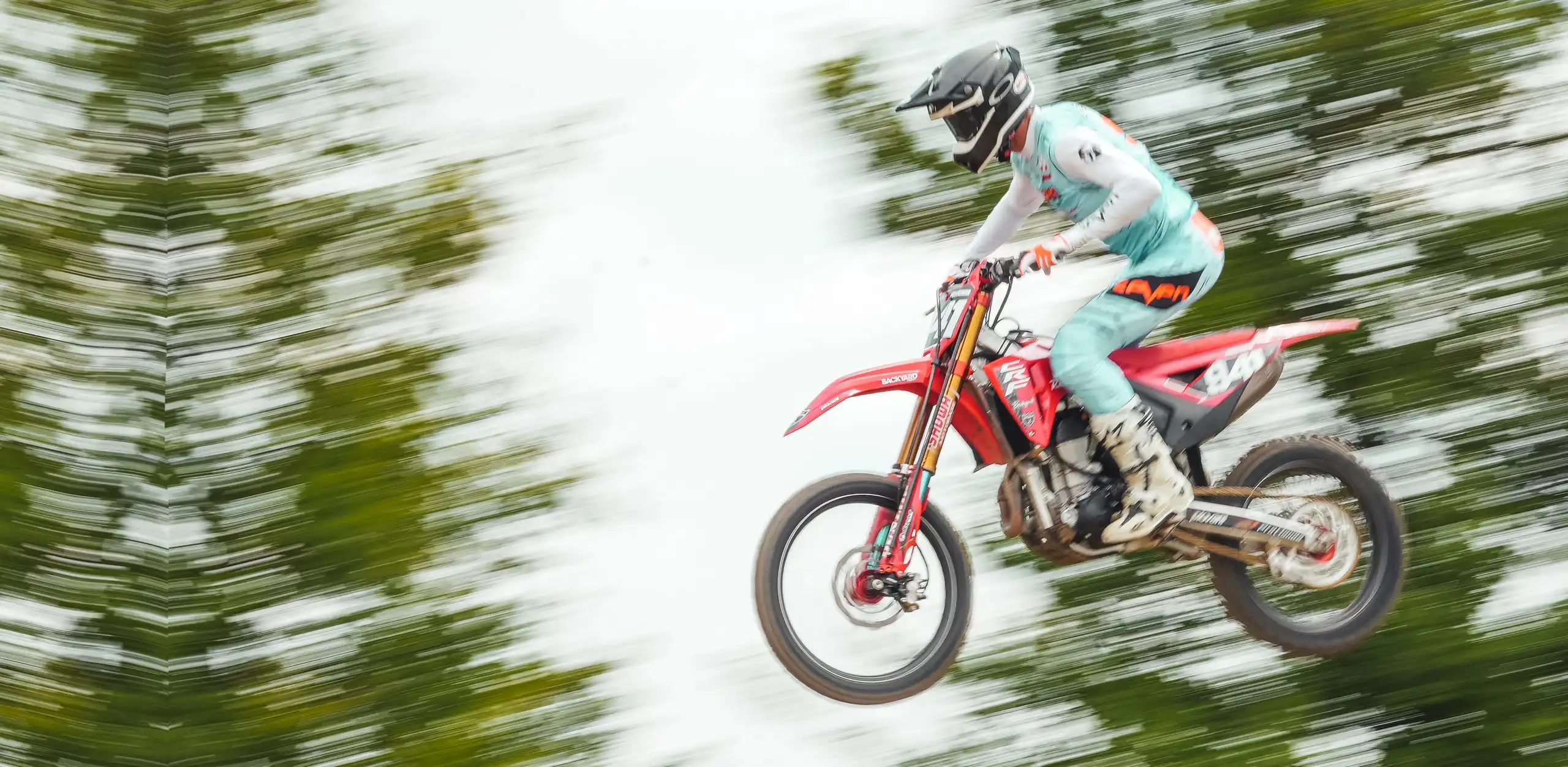 Angelo Pellegrini airborne on a motocross bike at an Italian supercross, with BYB Telemetry suspension sensors fitted to the forks.